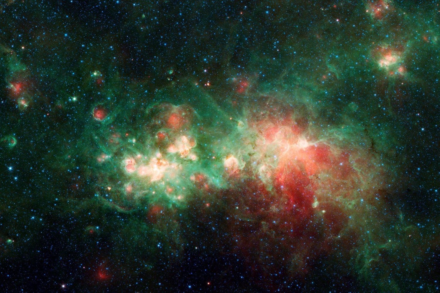 Clouds of green and red glowing gas, dotted with small bright knots of light.