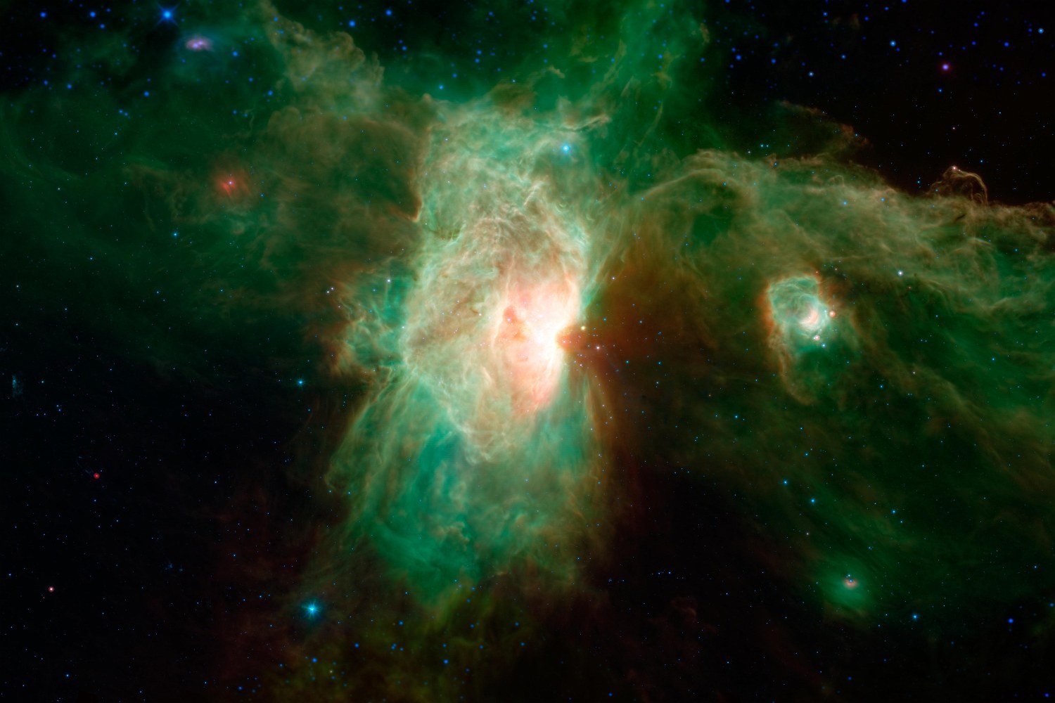 Clouds of green dust and glowing gas around a bright white core, in false colour.