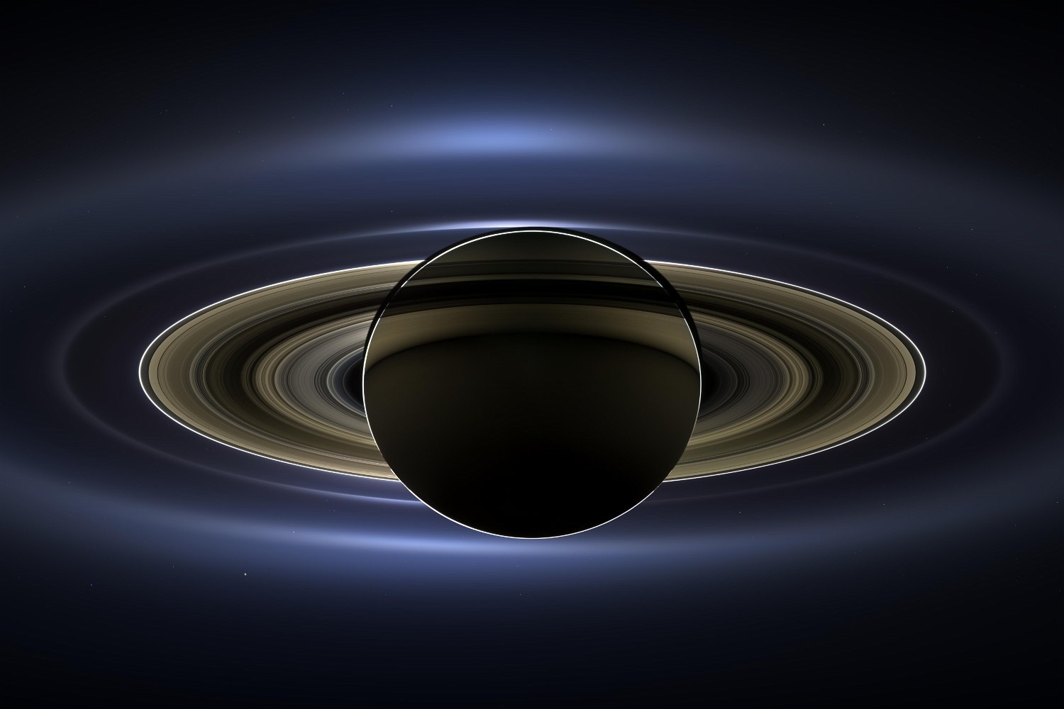 A ringed planet in silhouette against the light of its sun, the rings glowing in a wide, soft halo.